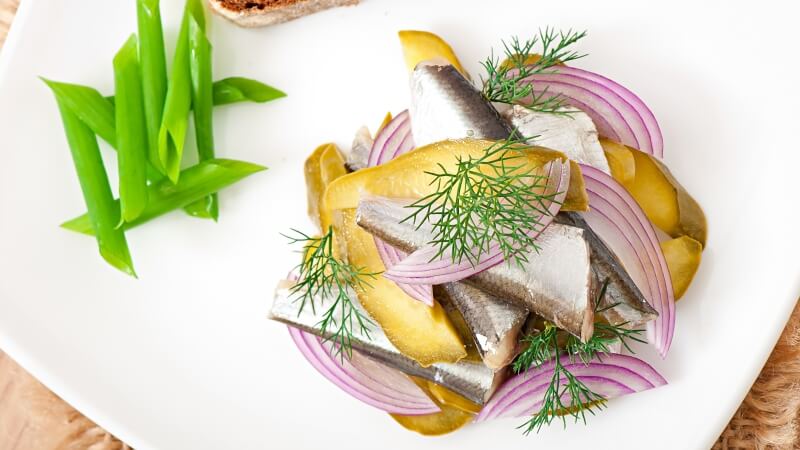 Śledzik w oleju z cebulą na talerzyku
