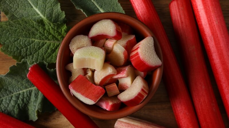 Czerwone łodygi rabarbaru z zielonymi liśćmi