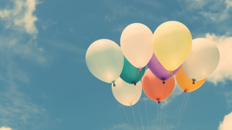 Kolorowe balony unoszące się w powietrzu - przedmioty na literę B w grze Państwa-Miasta