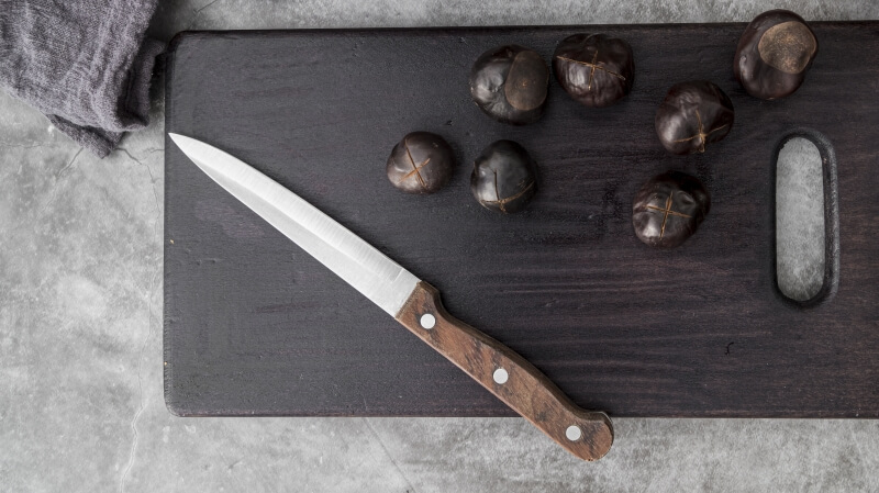 Ostry nóż kuchenny z drewnianą rękojeścią - przedmiot na literę N w grze Państwa-Miasta