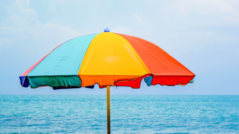 Kolorowy parasol przeciwdeszczowy rozłożony na tle nieba - przedmiot na literę P w grze Państwa-Miasta