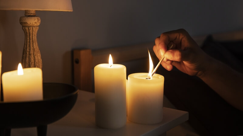 Zapłonięta świeca w eleganckiej szklance na drewnianym stole - przedmiot na literę Ś w grze Państwa-Miasta