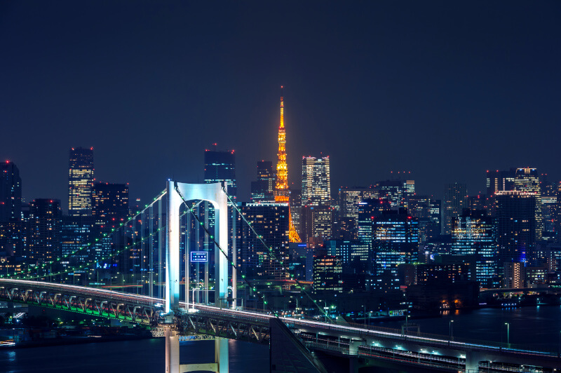 Nocna panorama Tokio z Wieżą Tokijską i mostem Rainbow Bridge — Tokio jest największym miastem świata pod względem ludności